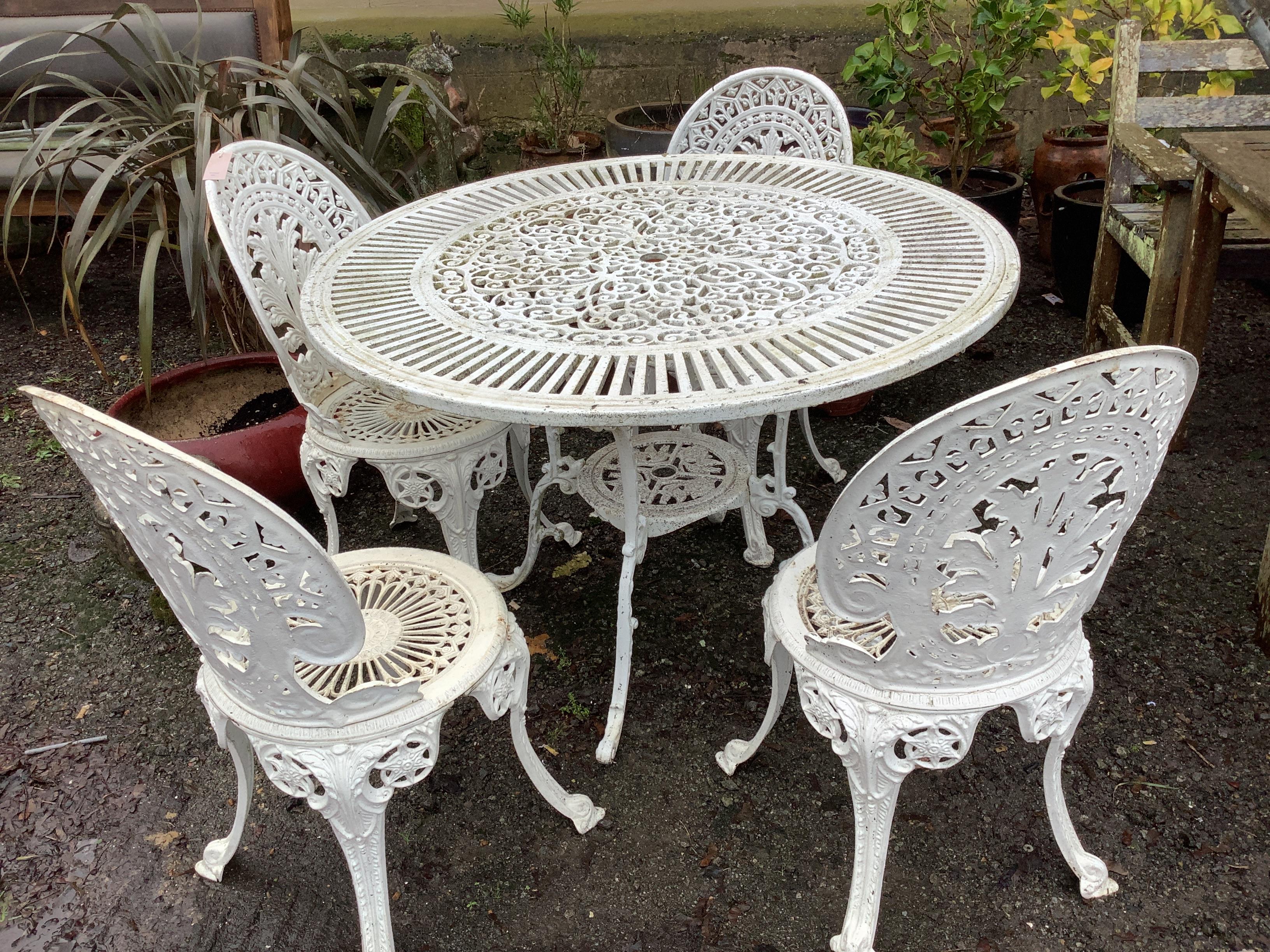 A Victorian style aluminium circular garden table, diameter 106cm, height 71cm, and four chairs